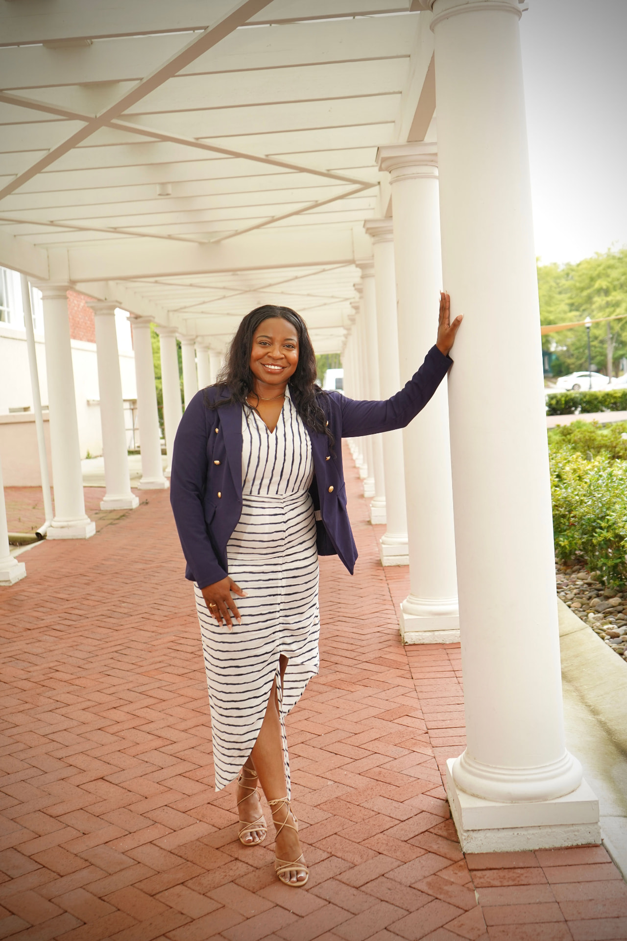 Kelli Sweat standing beside a row of white columns